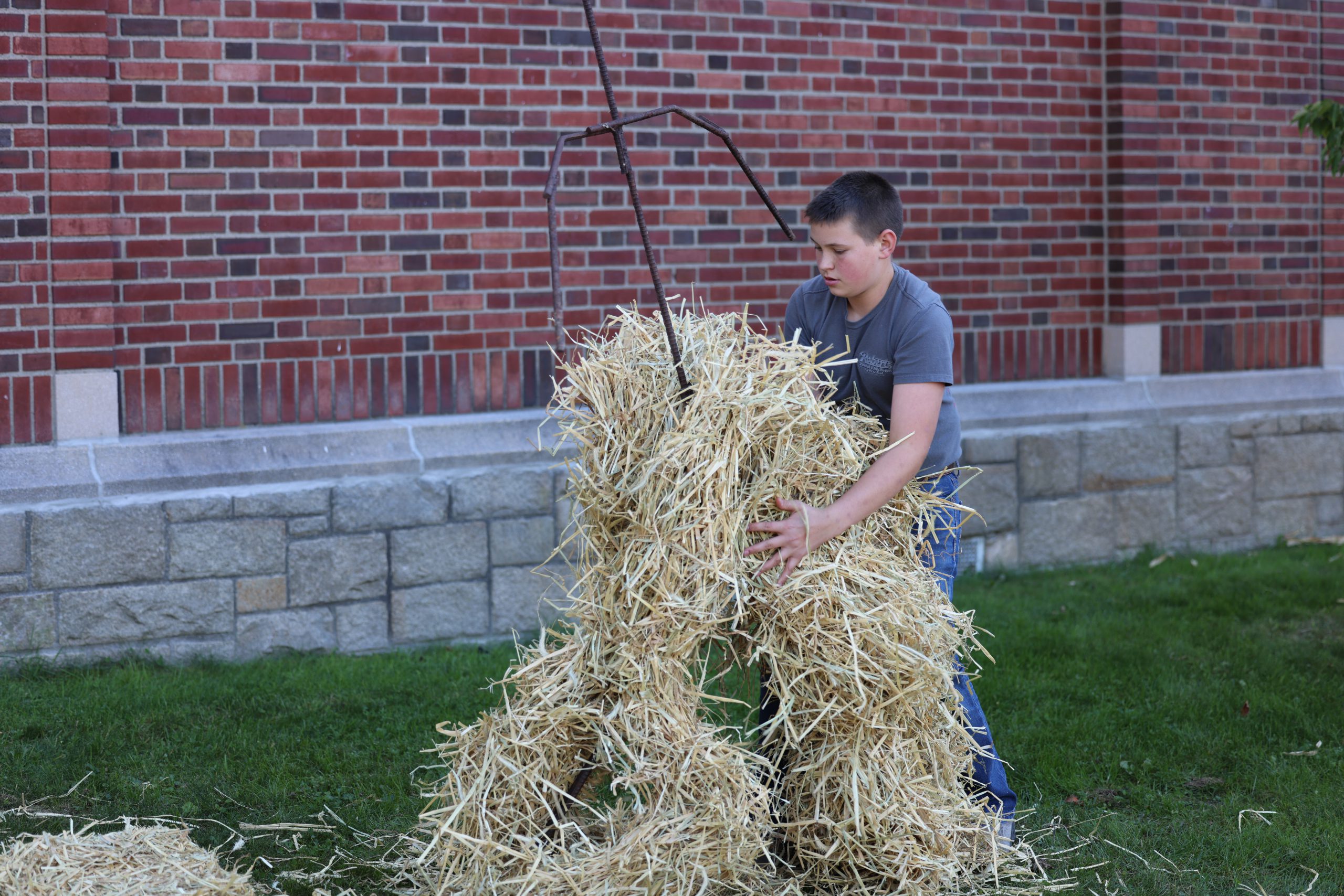 student lifting hay in front of middle school