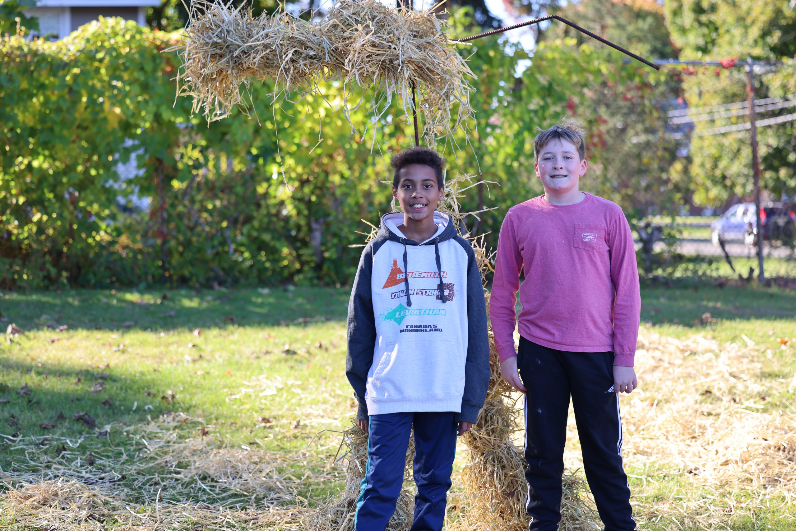 students pose in front of scarecrow