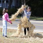 student lifting hay in front of middle school