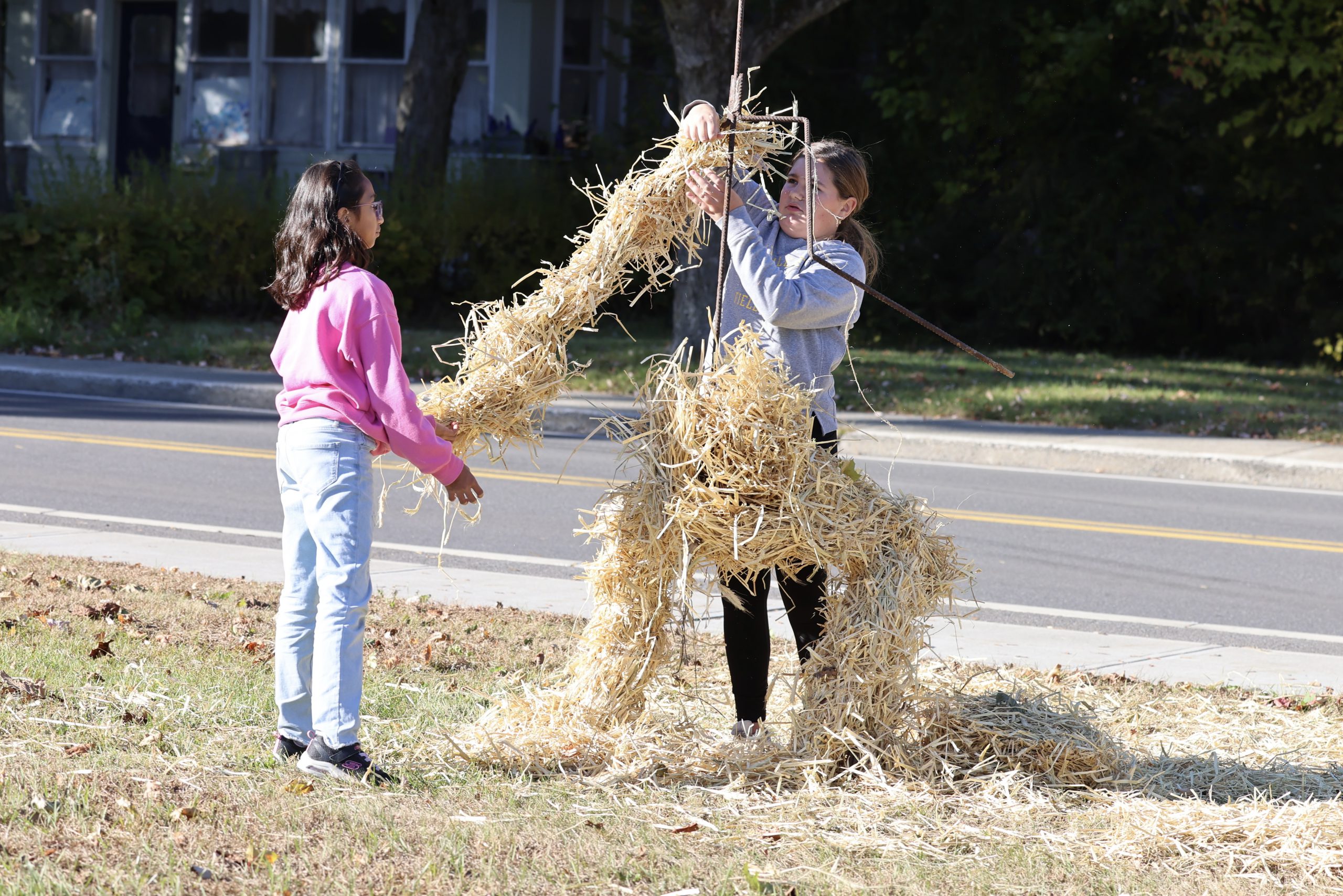 student lifting hay in front of middle school