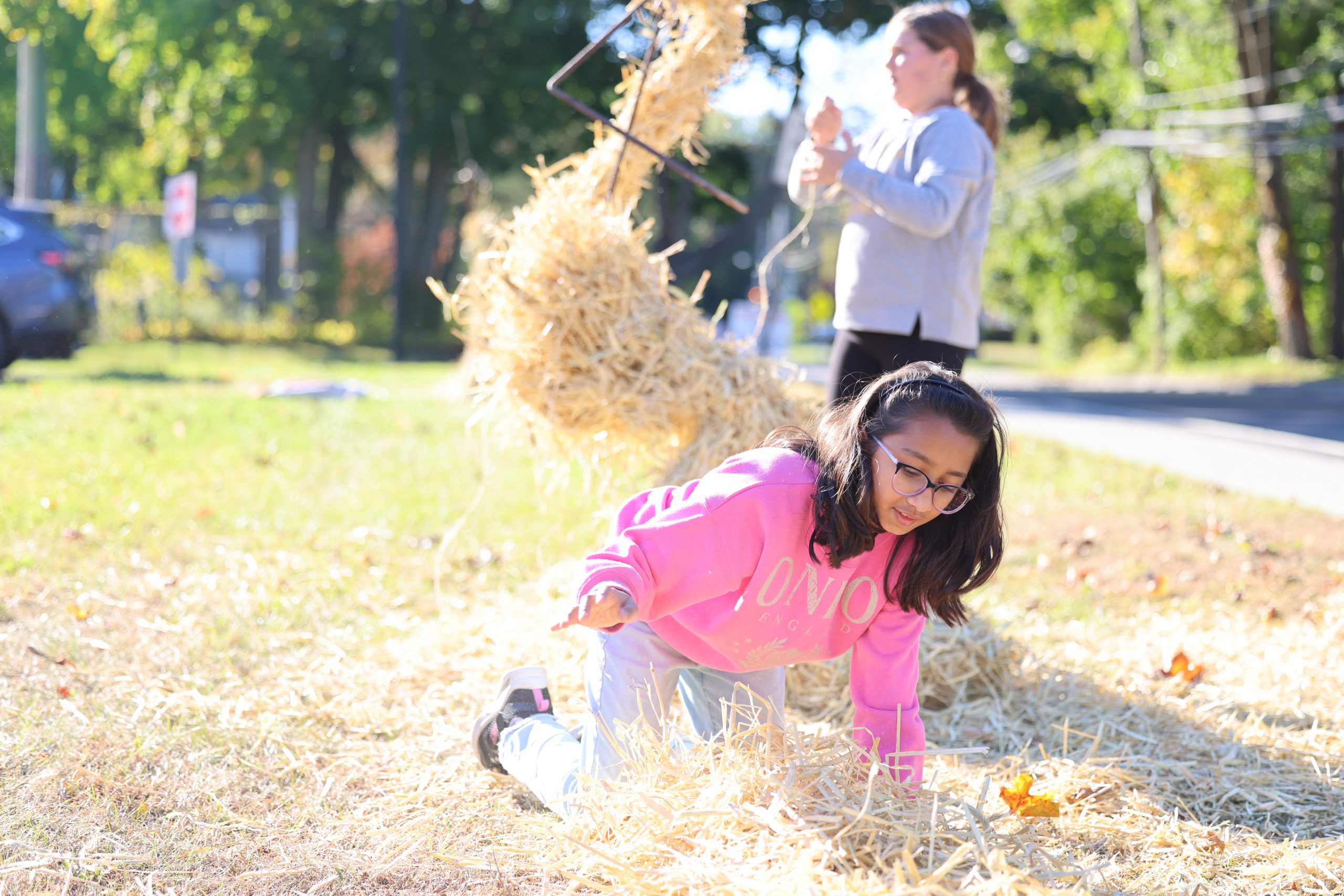 student lifting hay in front of middle school