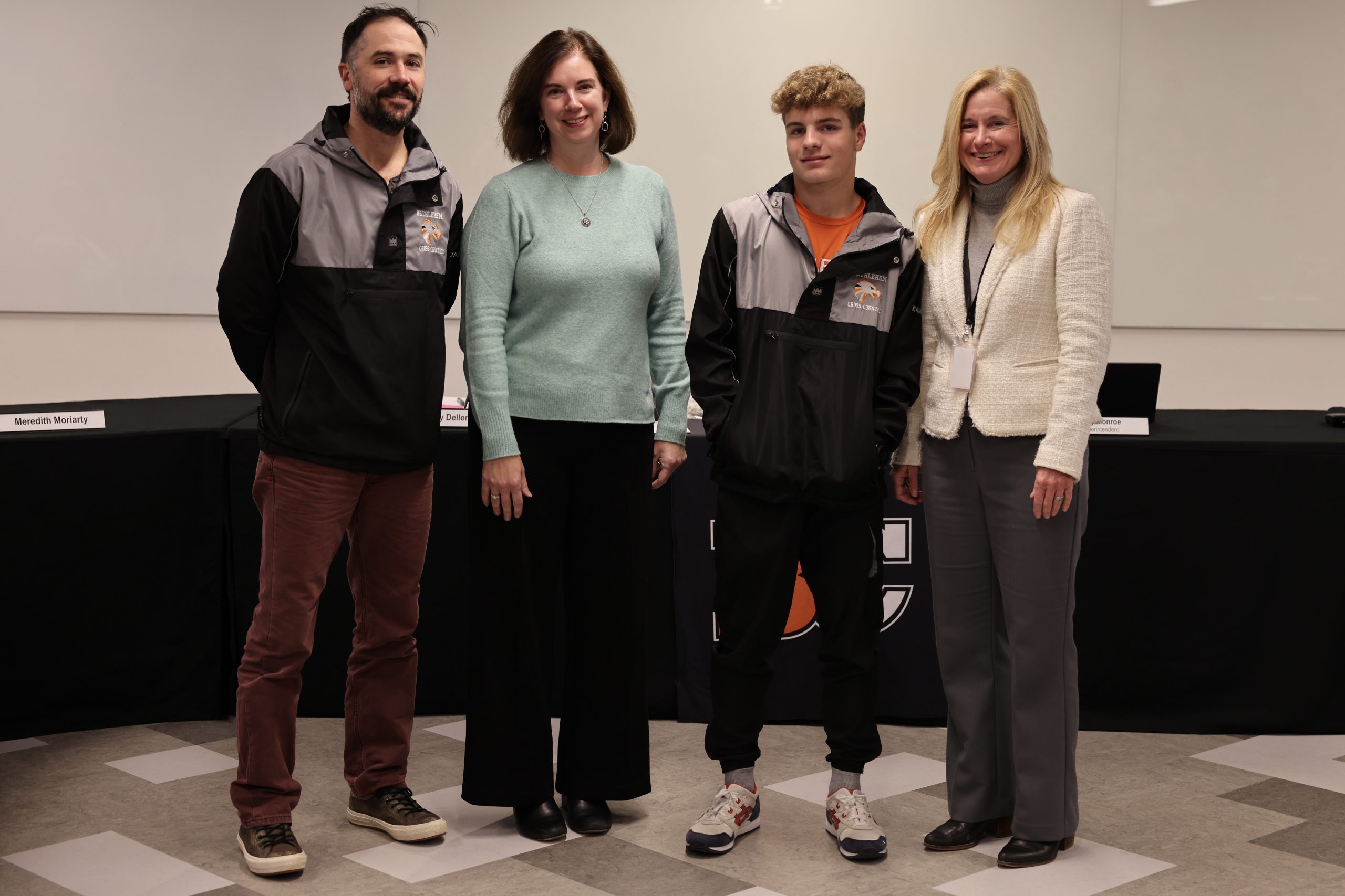 Photograph of Superintendent Jody Monroe, Board of Education President Holly Dellenbaugh, Boys Cross Country team member Calvin Howard and Coach Andrew Rickert