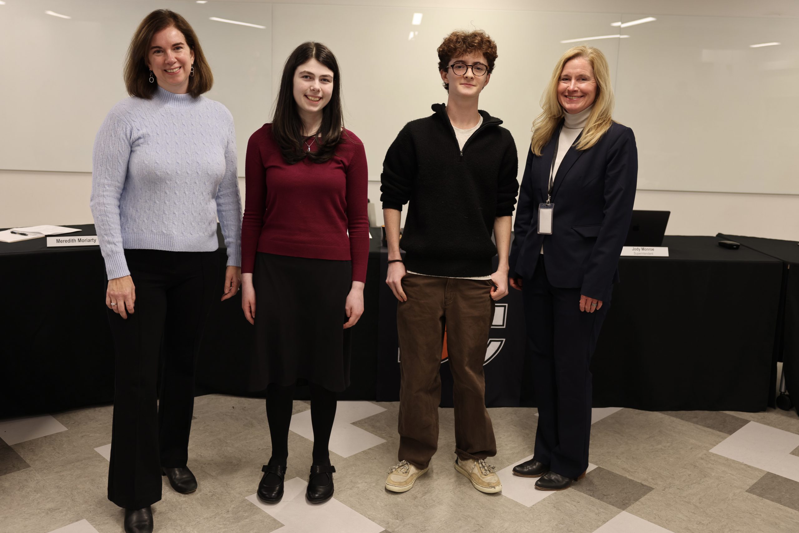 four people pose for photos