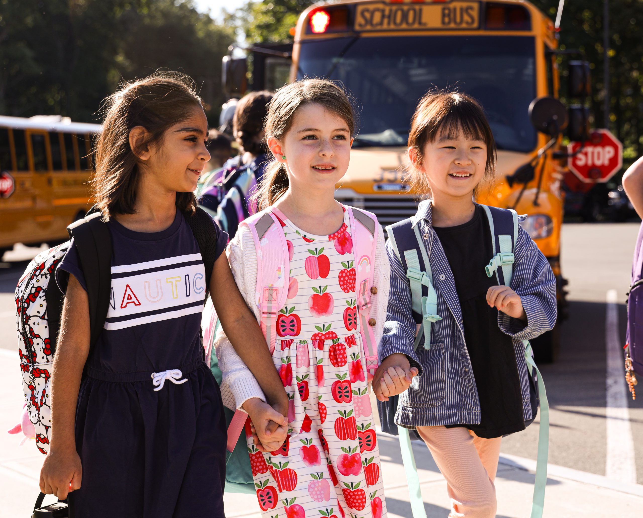 three students walking and holding hands